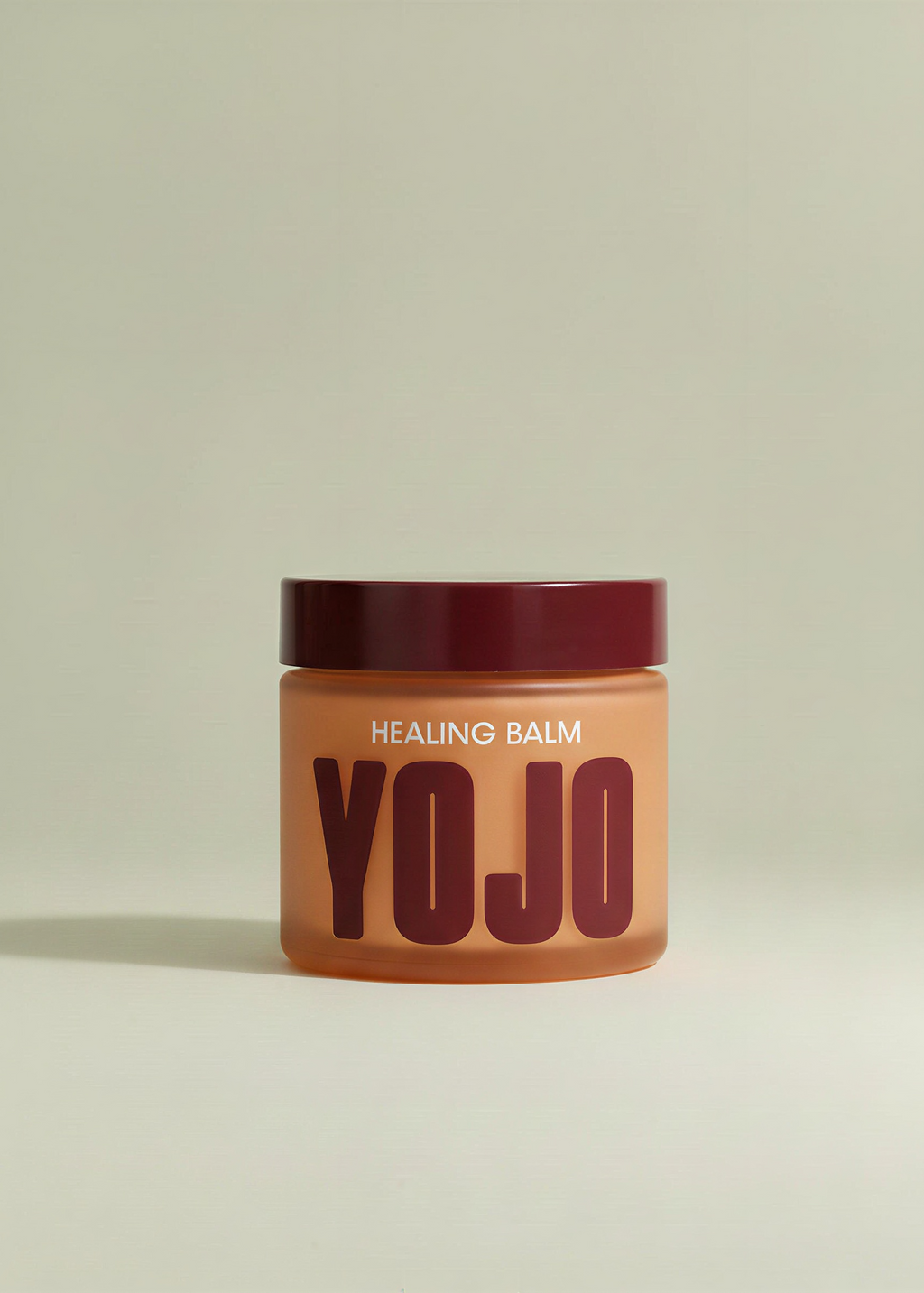 Jar of 'YOJO' healing balm on a light beige background